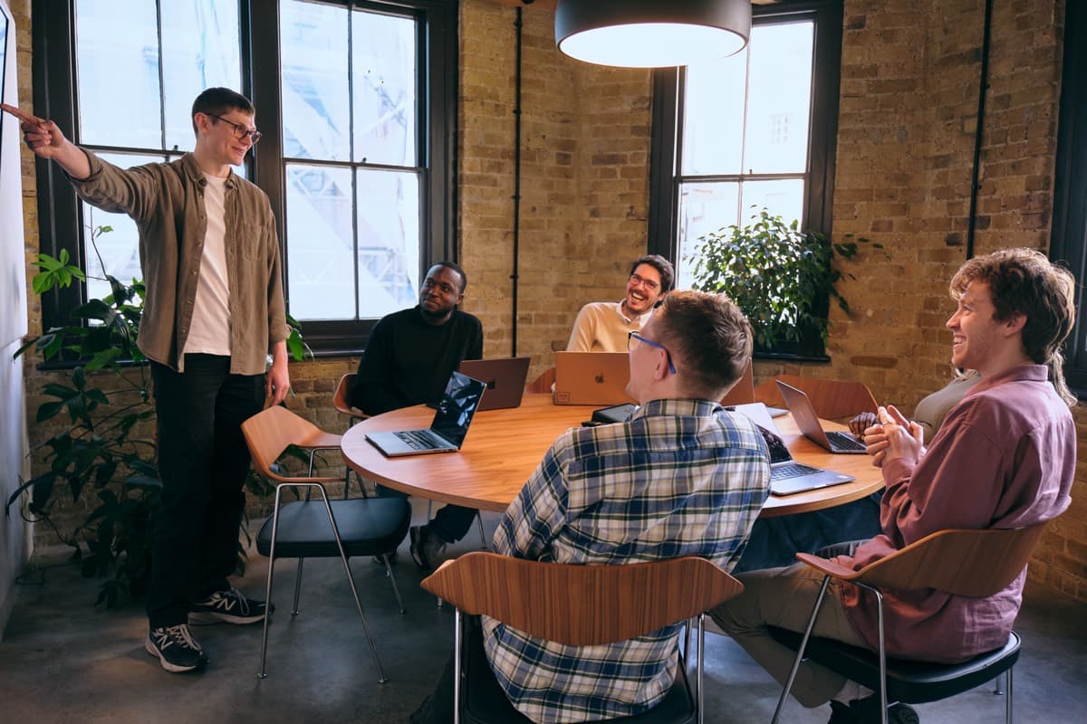 Someone presenting to a round table of people with laptops in the Pixie Labs studio